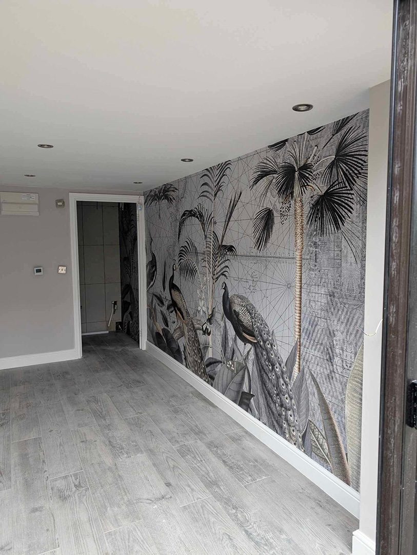 Freshly decorated room with feature wallpaper and grey flooring