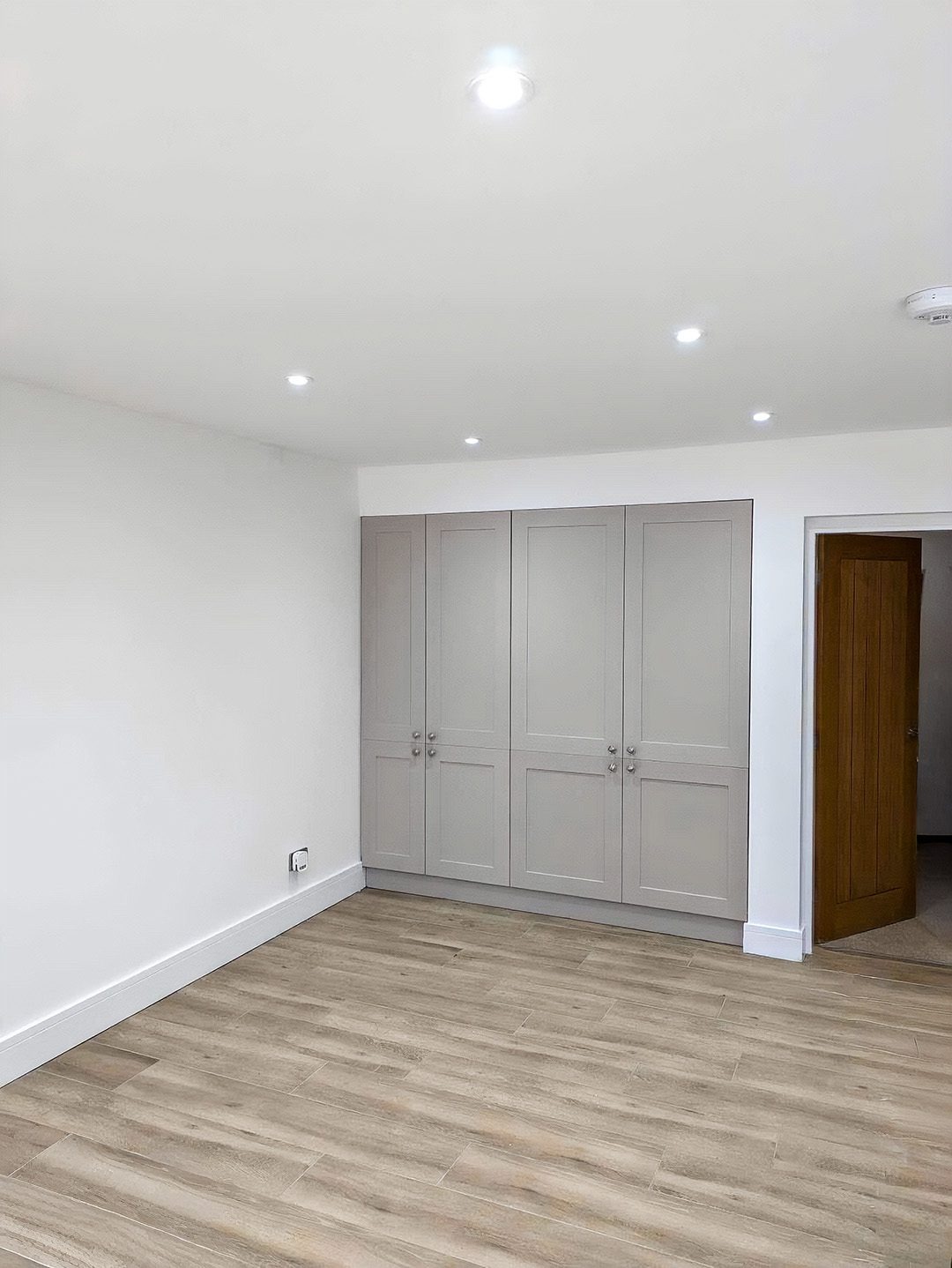 Bright repainted rental room with grey fitted wardrobe doors